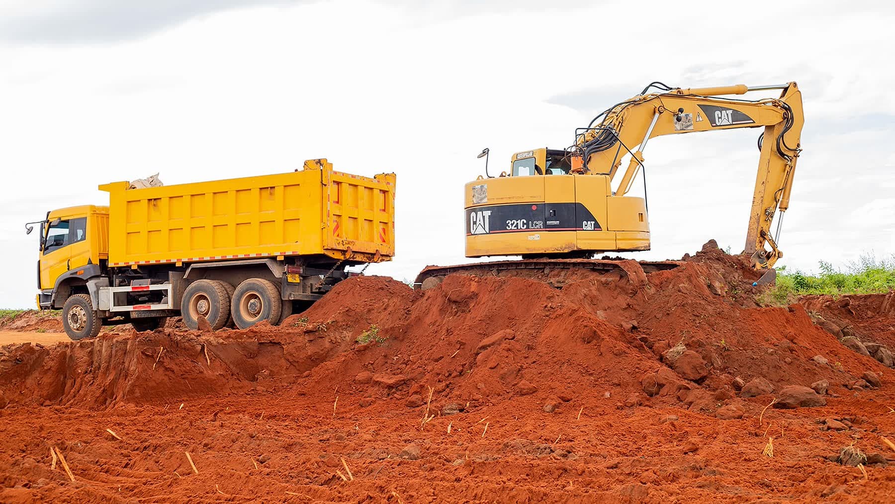 Ellyz excavator loading a tipper truck on a bulk earthworks cut