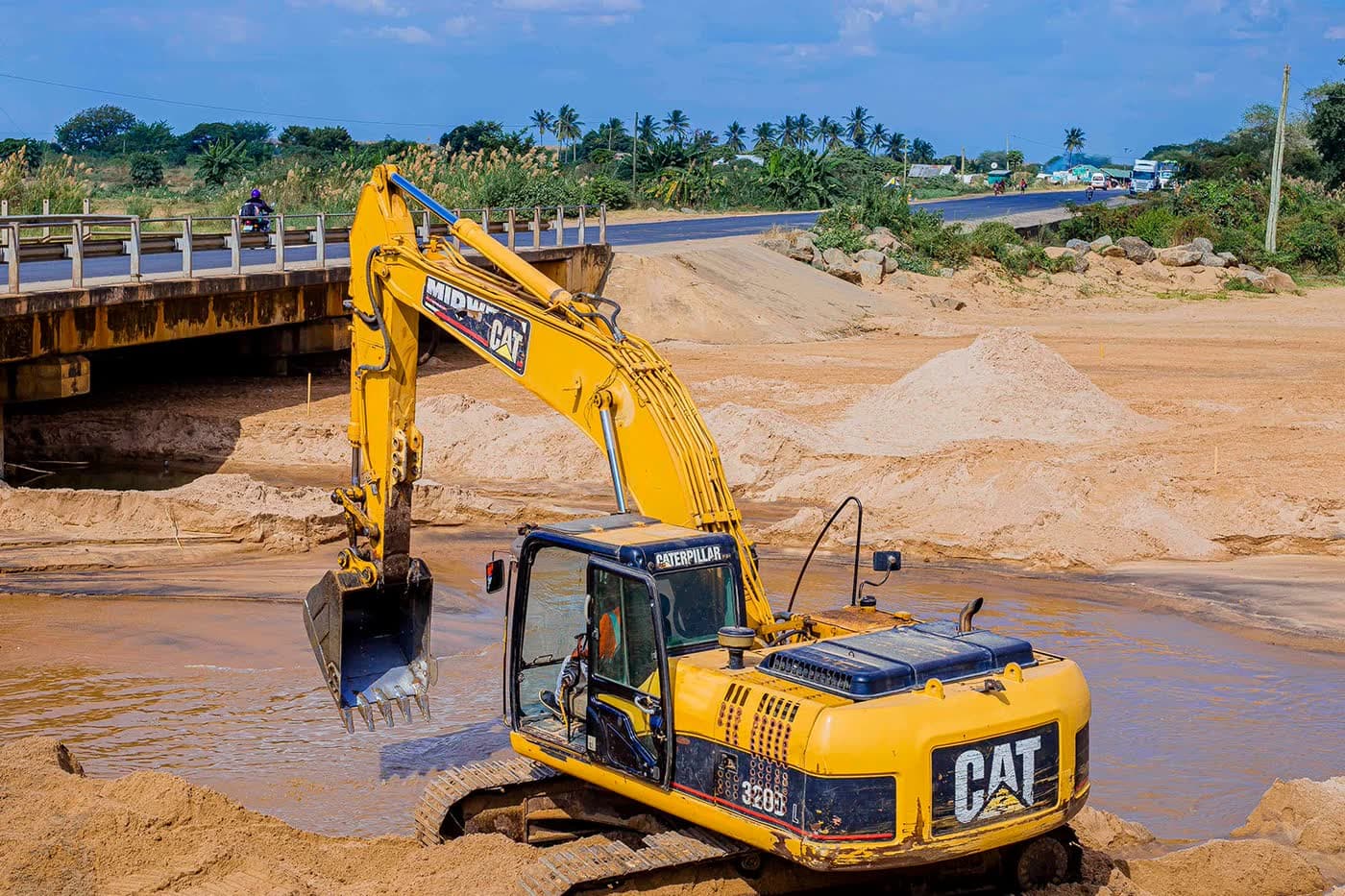 Ellyz excavator working a river crossing beside a road bridge in Tanzania