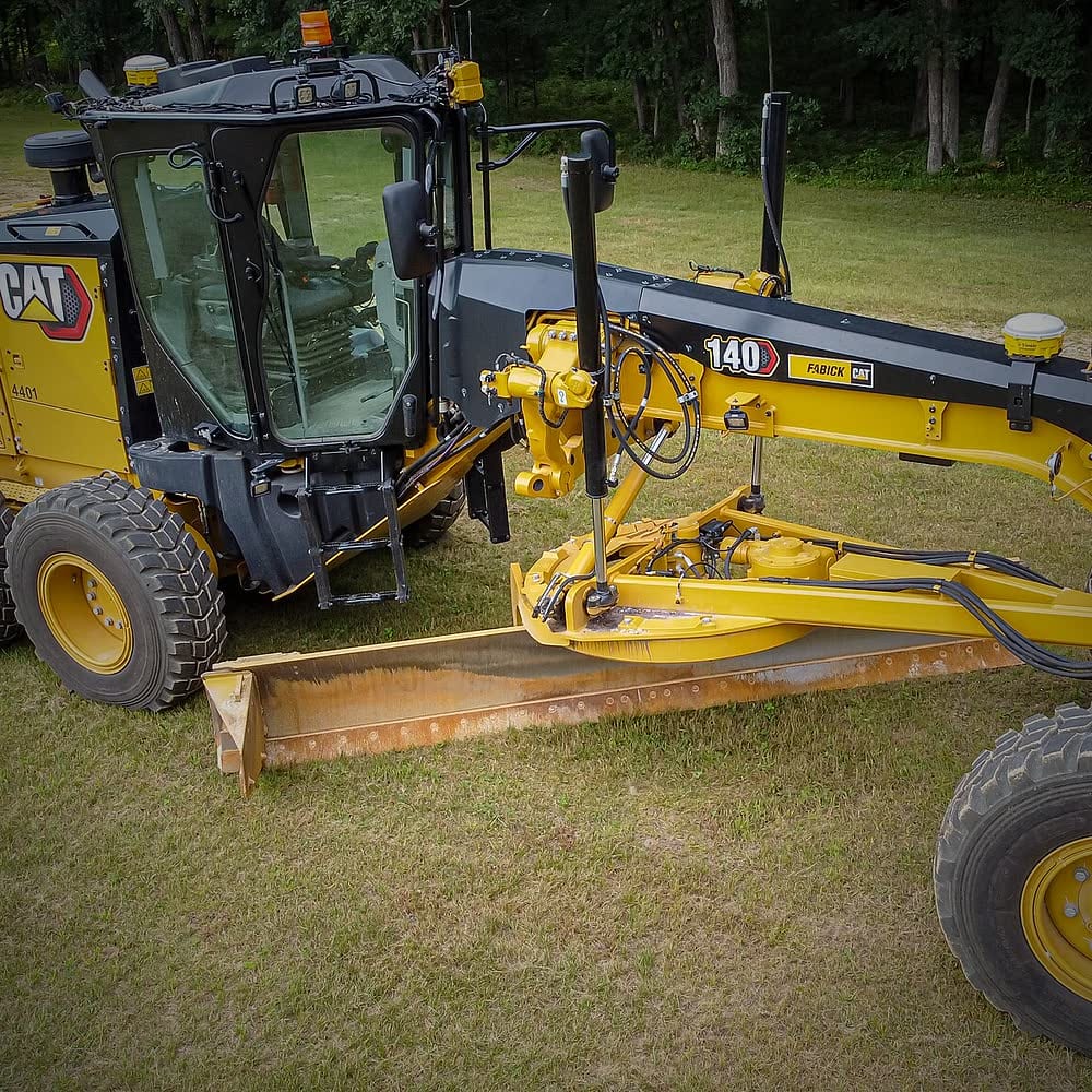 Motor grader with its blade lowered for levelling