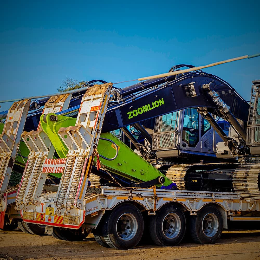 Tracked excavator loaded on an Ellyz lowbed trailer under abnormal-load signage
